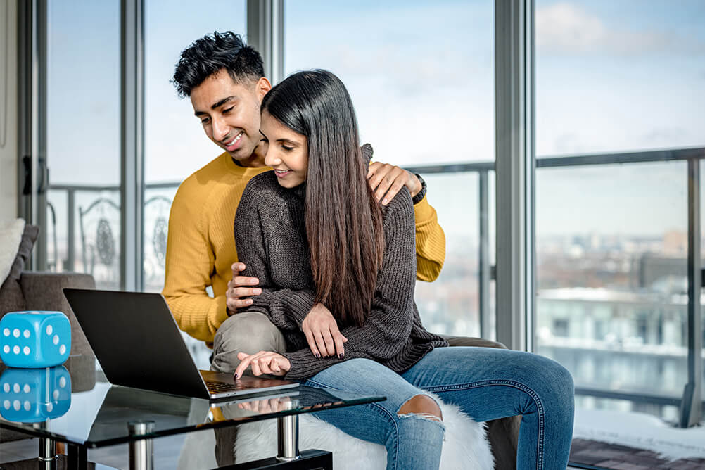 Couple sitting in front of laptop trying to pick lottery numbers