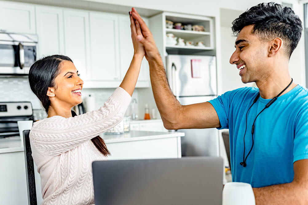 Two young indian people smiling and celebrating their win