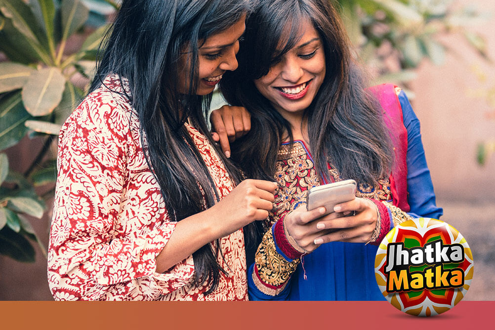 Two women searching what is Matka on their smartphone