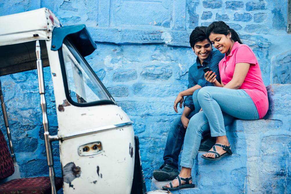 Indian couple next to rickshaw playing online satta matka