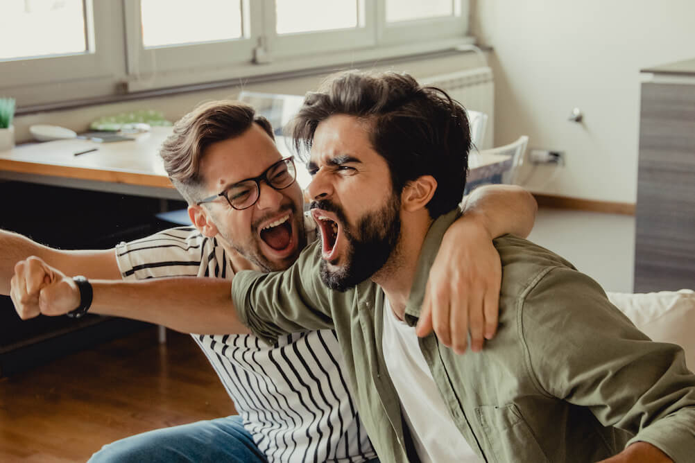 Two Guys Cheering Watching Sports on TV 